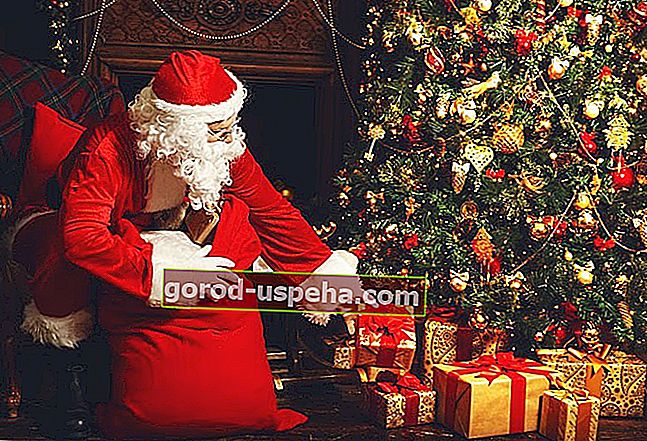 Święty Mikołaj umieszcza prezenty u podnóża drzewa